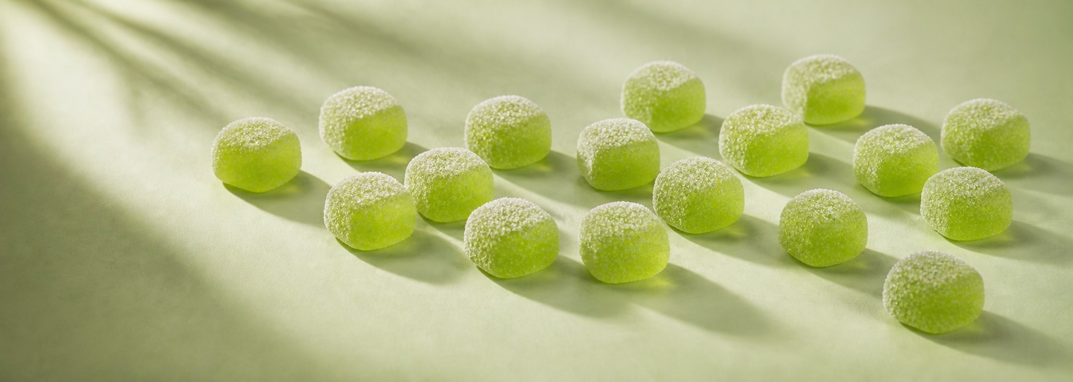 Assortment of symmetrical, sugar-coated Green Apple gummies